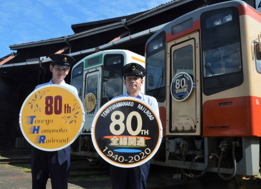 自らデザインした８０周年記念ヘッドマークを手にする滝口さん（右）と竹内さん＝浜松市天竜区二俣町の天竜二俣駅