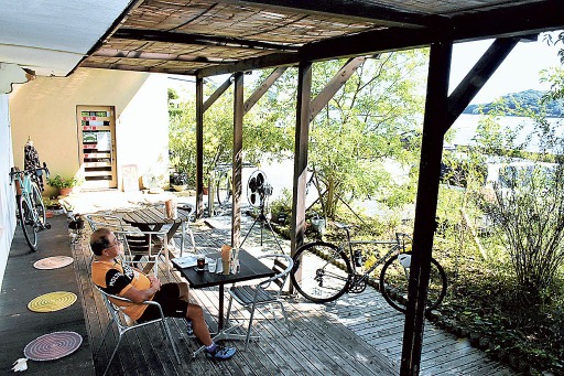 浜名湖を見渡せるテラスで休憩するサイクリスト＝湖西市利木のはまなこみんなのカフェ湖西店