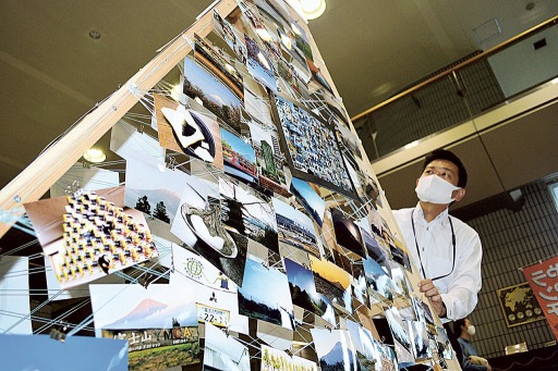 市民らが暮らしの中で見つけた富士山に関連する写真が並ぶ展示台＝富士宮市役所