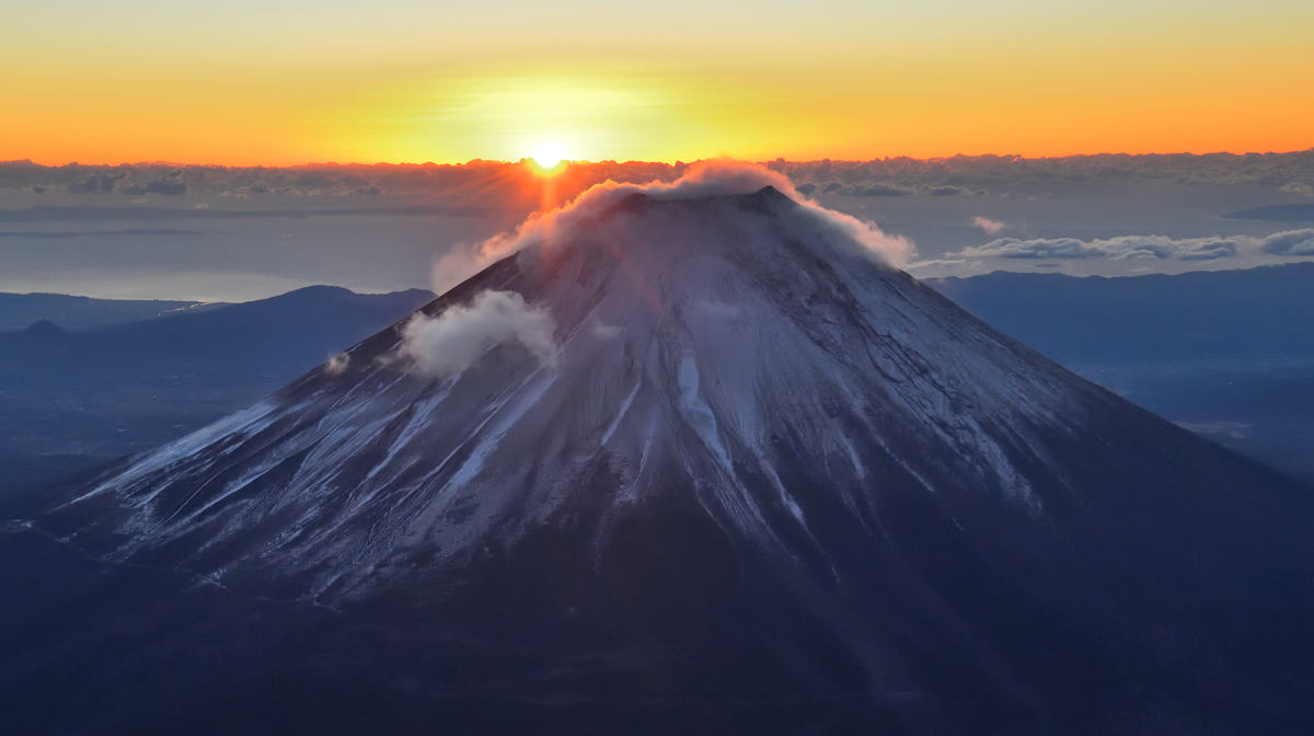 富士山の背に昇る初日の出＝１日午前６時５０分ごろ、富士宮市と山梨県の県境付近（静岡新聞社ヘリ「ジェリコ１号」から）