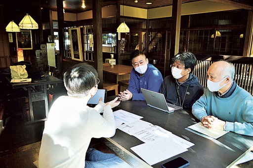 「山喜旅館」で通信環境を調査する伊東観光協会の関係者や山田幹久社長（右）ら。和建築の食堂は現在もリモートワークの作業スペースに開放している＝２０２０年１２月中旬、伊東市
