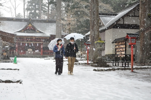 雪が降る中、参道を歩く参拝客＝１２日午後、小山町須走の冨士浅間神社