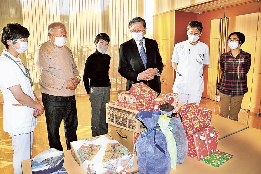 子どもへのプレゼントを囲む八木洋さん（左から２人目）、望月智江さん（同３人目）と小児科関係者＝２０２０年１２月中旬、長泉町の県立静岡がんセンター