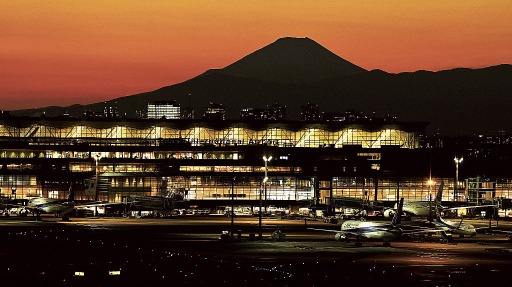 夕闇に浮かぶ富士山のシルエット。手前は羽田空港の国際線のターミナル＝５日、東京都大田区