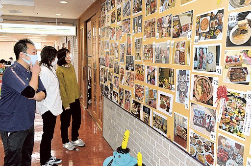 ロビーの壁に貼り出されたちらしずしやカニなどの写真。職員は施設からの支援金で料理や食材を購入した＝藤枝市の「愛華の郷」