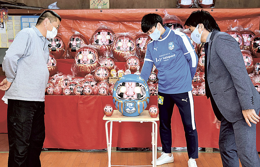 芦川博将代表（左）から青いだるまを受け取った安在達弥選手（中）と山崎宏さん＝富士宮市の杉山ダルマ店
