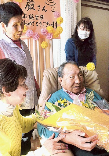 花束を受け取り、ほほえむ袴田巌さん（手前右）。後列左は姉の秀子さん＝１０日、浜松市中区