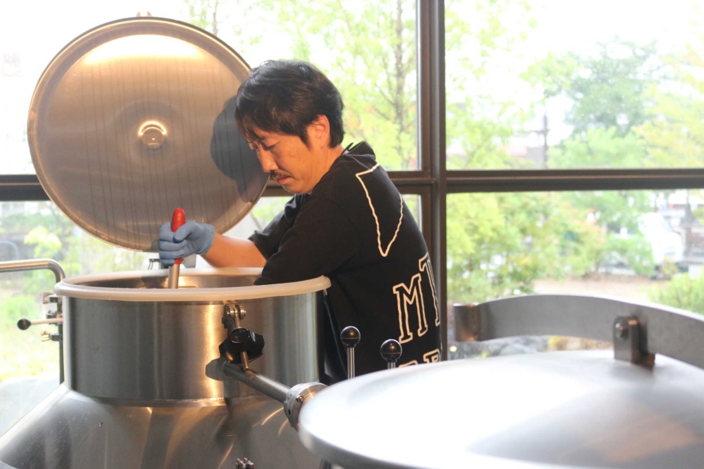 仕込みタンクのビールの状態を確認する会森隆介さん＝富士宮市のマウントフジブリューイング