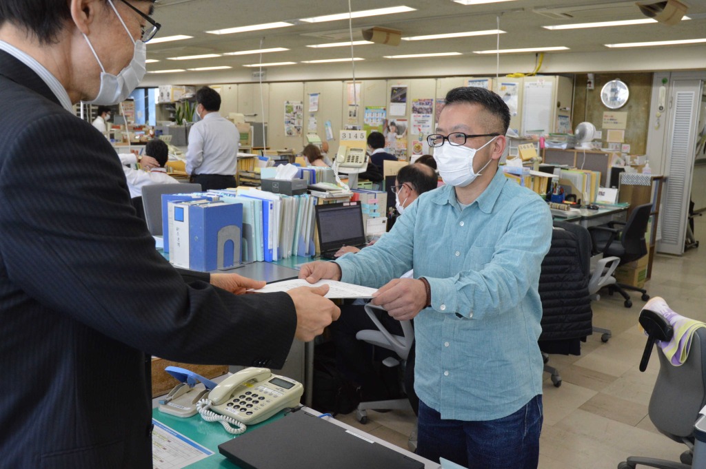 本多伸治課長（左）に要望書を手渡した鈴木げん代表＝２６日午後１時半ごろ、静岡県庁