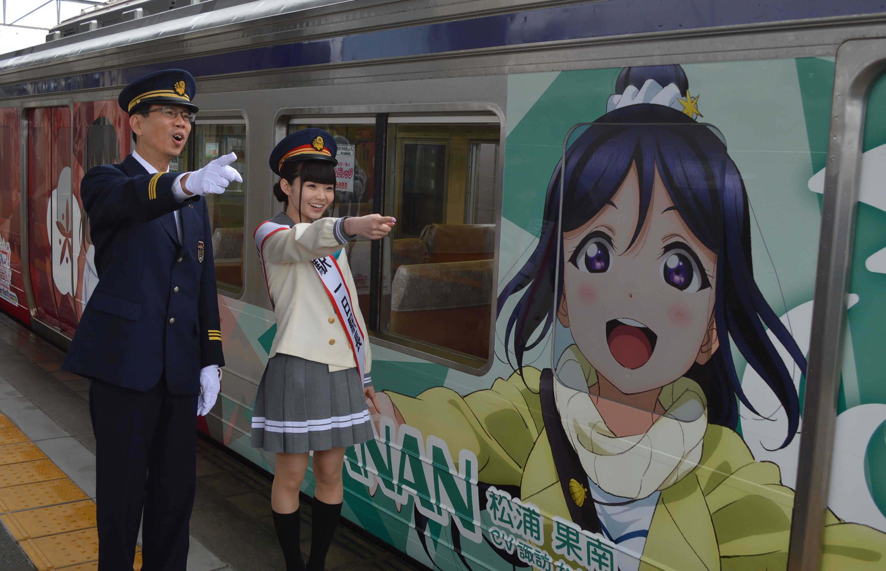 伍堂社長（左）とともに出発合図を出す諏訪さん＝伊豆箱根鉄道三島駅