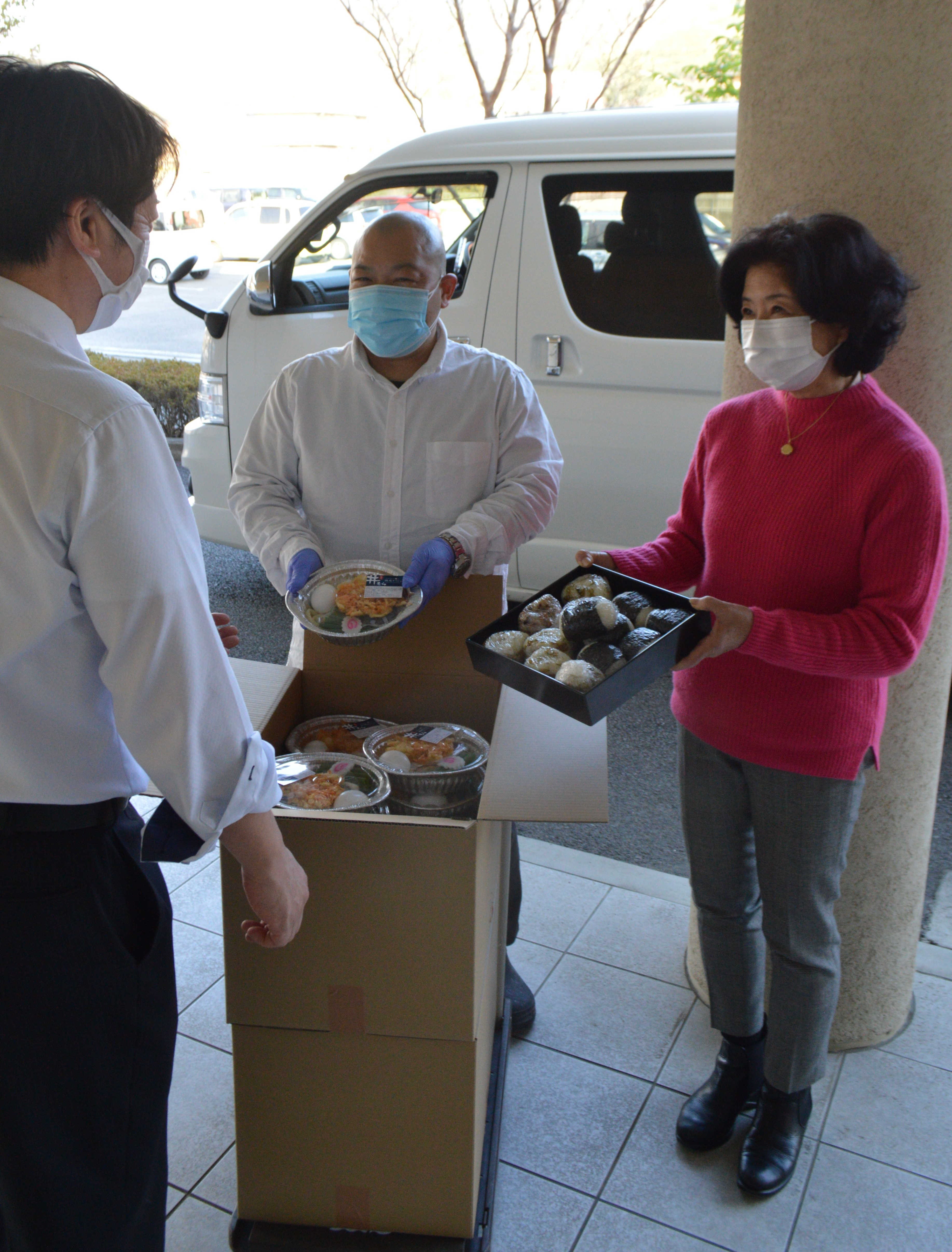 施設を応援しようと、施設職員（左）に支援品を届ける住民ら＝西伊豆町