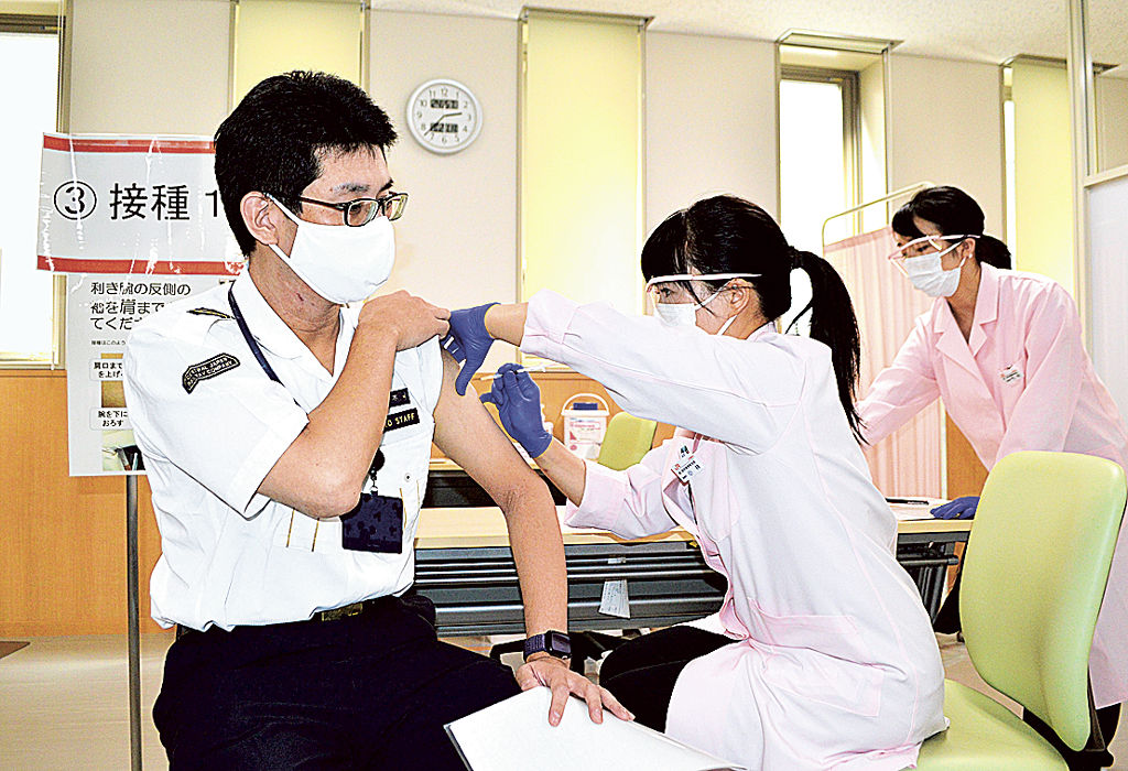 職域接種で新型コロナウイルスワクチンの接種を受けるＪＲ東海の社員（左）＝２１日午後、静岡市葵区