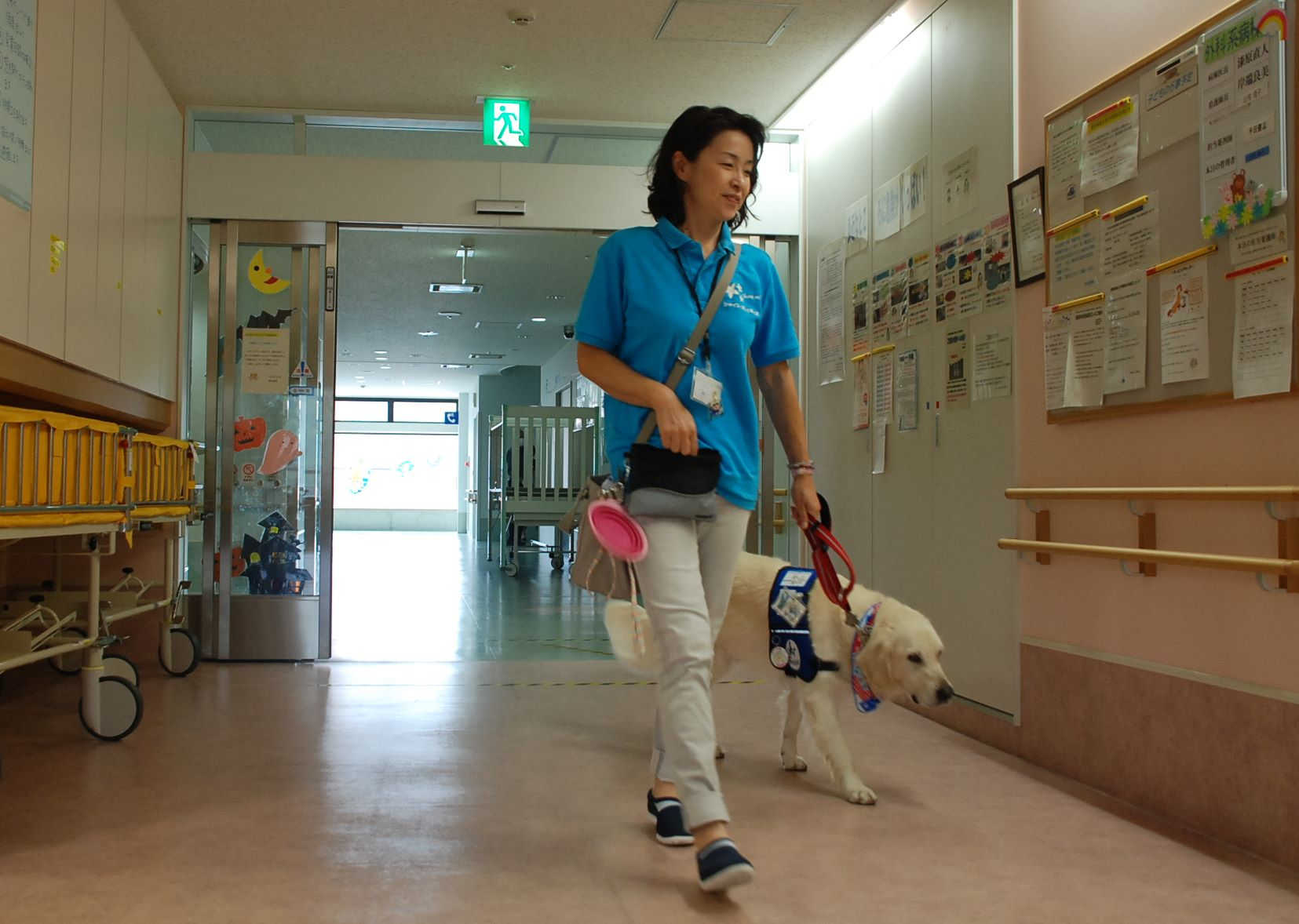 ヨギと病棟を歩く鈴木恵子さん＝１０月中旬、静岡市葵区の県立こども病院