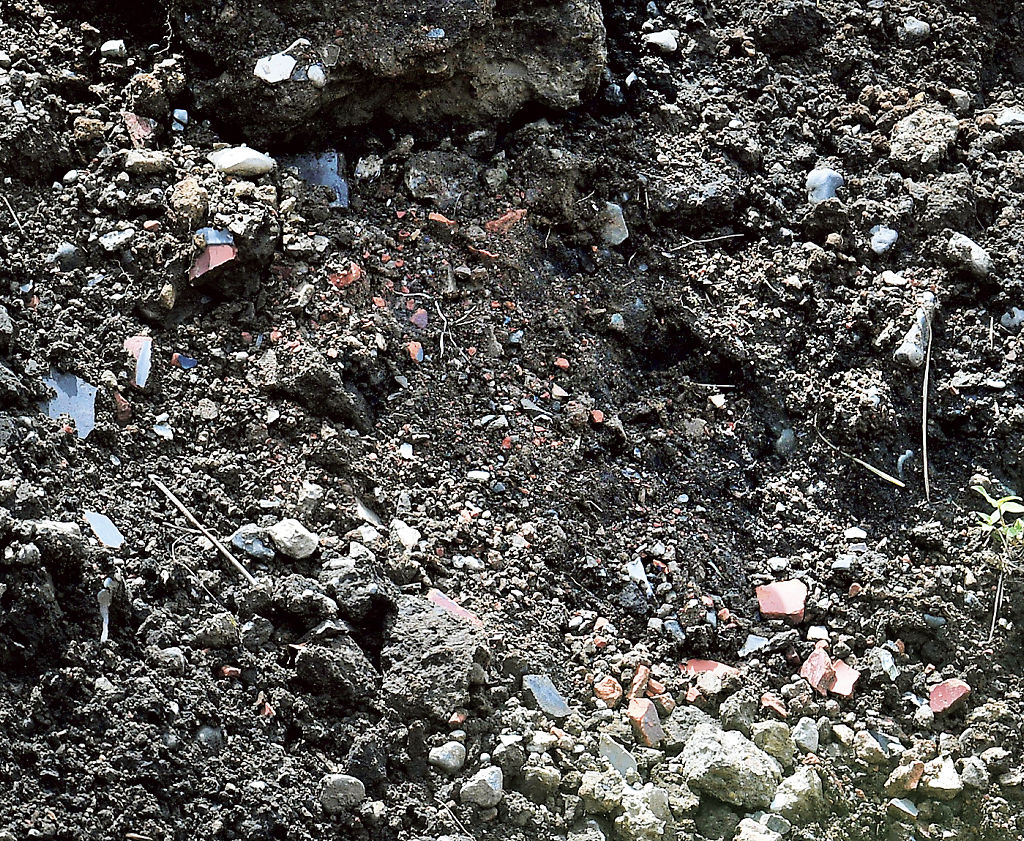 崩落した断面に露出した人工物と見られる異物＝１１日午前１０時６分、熱海市伊豆山