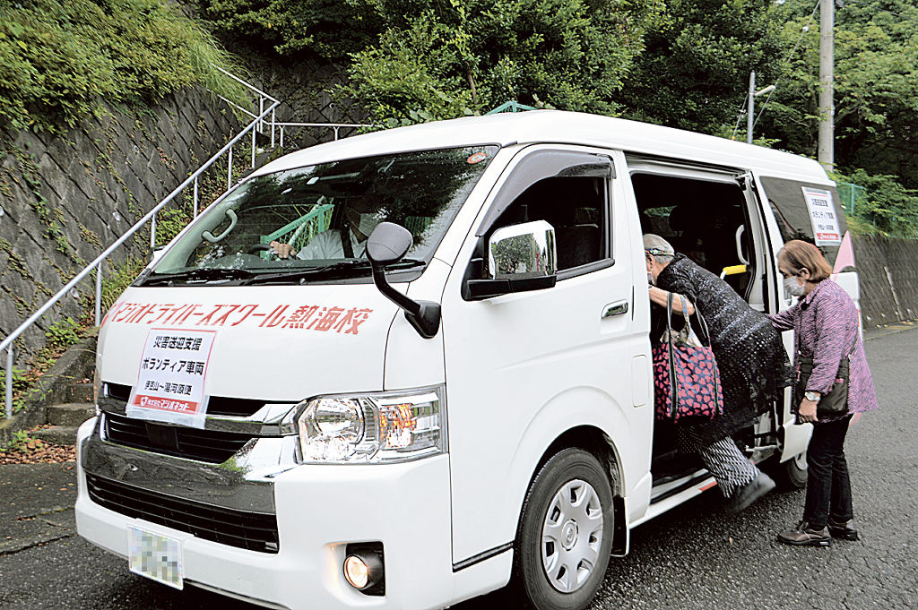 無料運行バスに乗り込む七尾地区の住民ら＝１４日午前、熱海市伊豆山（画像の一部を加工しています）