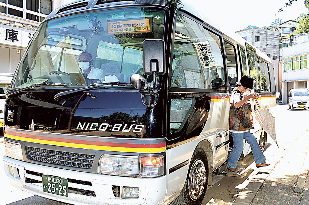 熱海青年会議所が運行を開始した支援バス。初日は通院などのために乗車する被災者の姿がみられた＝２１日午後、熱海市伊豆山