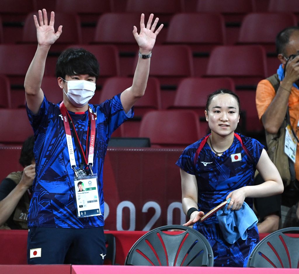 卓球女子シングルスで銅メダルを獲得した伊藤美誠とともに笑顔で手を振る松崎太佑コーチ（左）＝２９日夜、東京体育館（写真部・久保田竜平）