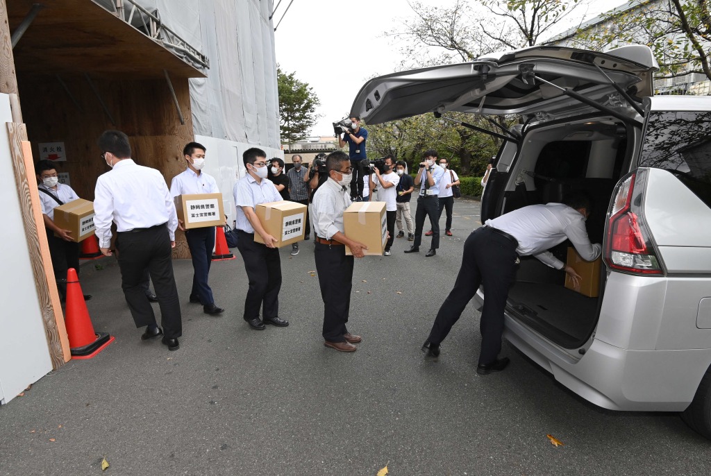 市議会事務局からの押収品を運び出す捜査員＝８日午後、富士宮市役所
