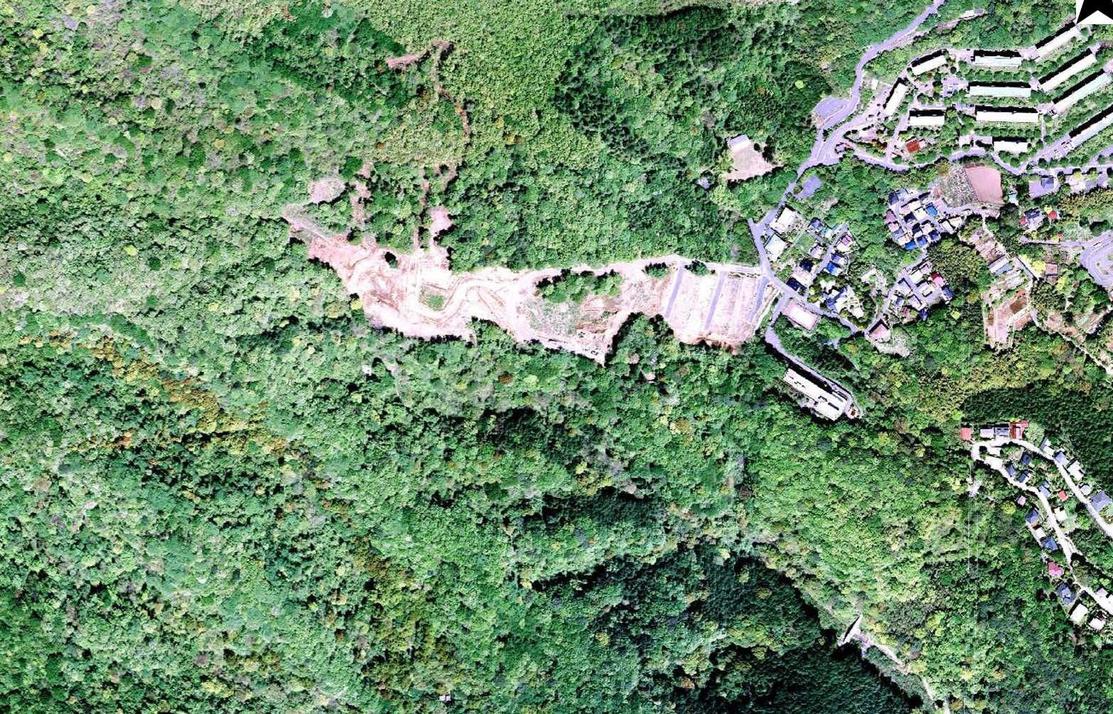 ▶２００６年９月　土石流起点付近を撮影した航空写真。盛り土部分は森林のままで、造成は始まっていない