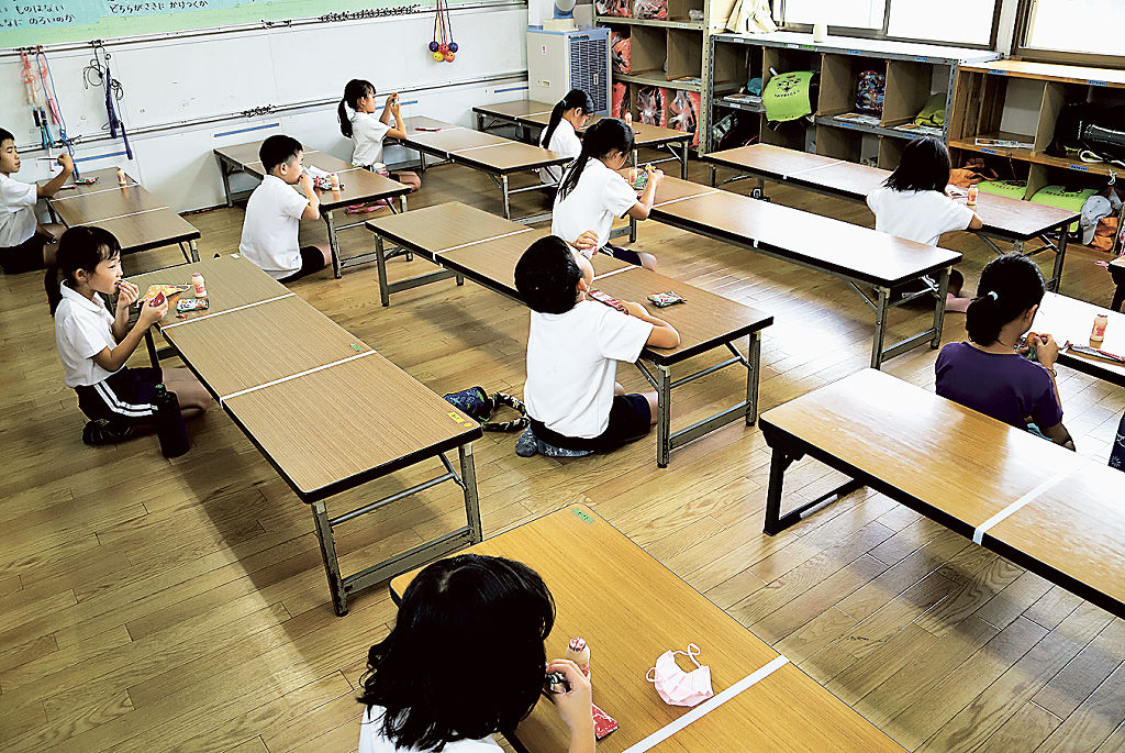 前後左右に距離を設け、静かにおやつを食べる児童たち=8日、焼津市内