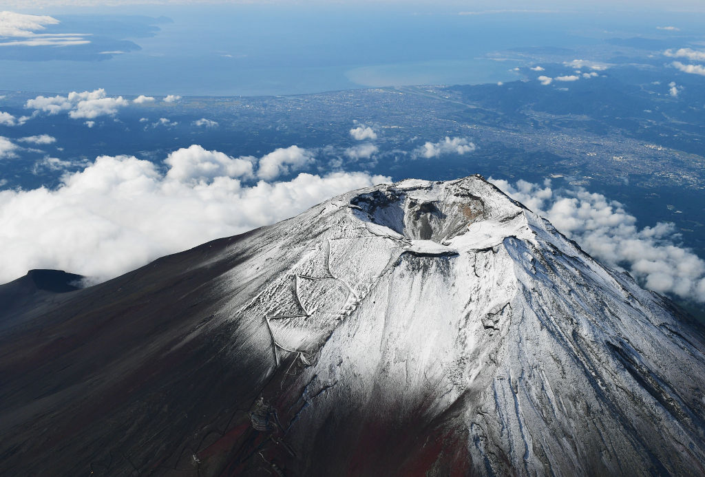 ７日、山頂付近に雪が積もった富士山。「初冠雪」と発表されたが、取り消された（静岡新聞社ヘリ「ジェリコ１号」から）