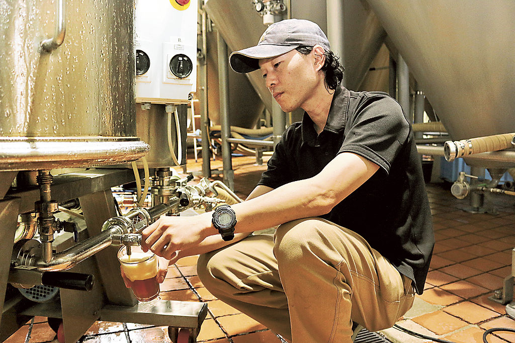 検査のためにビールを取り出す加田雄一郎さん＝８月下旬、御殿場市のＧＫＢ