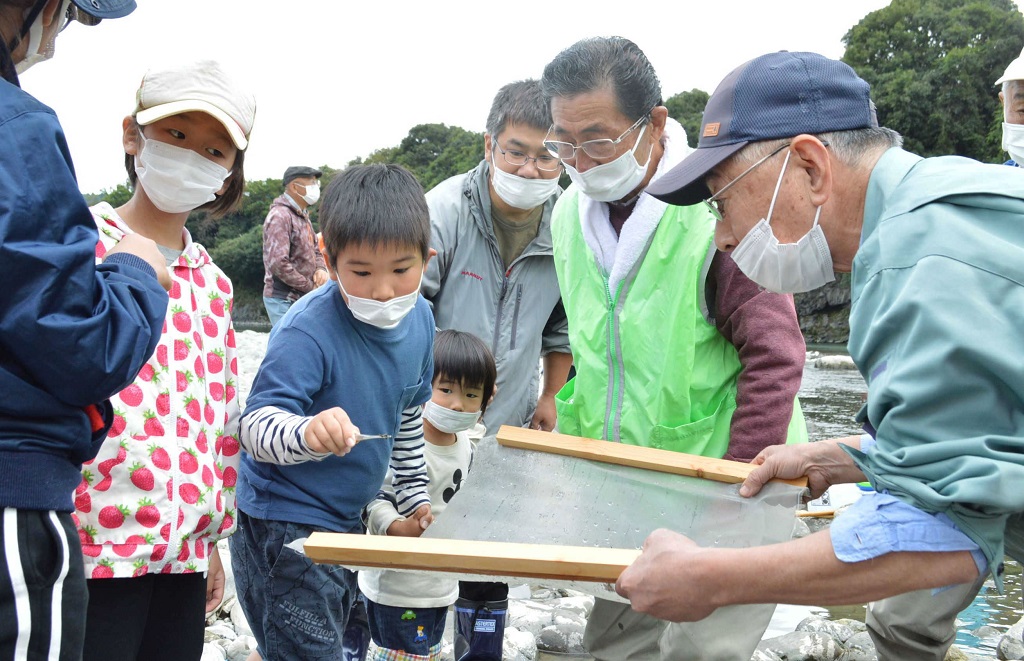 富士川本流でアユの産卵床を作った後、底生生物（水生昆虫類）の観察をする地元の子供たち＝２４日午後、富士宮市沼久保