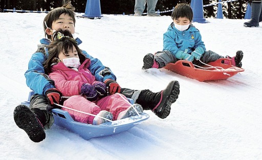ゲレンデでそり遊びを楽しむ子どもたち＝富士市の富士山こどもの国