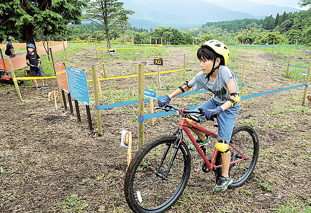 マウンテンバイクでコースを疾走する子ども＝富士市の富士山こどもの国