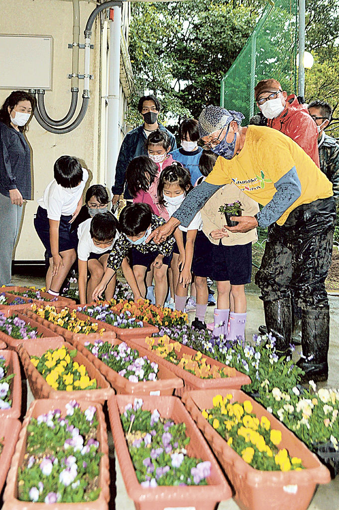 児童に花の紹介をする八ケ岳グリーンネットワークの南條登代表（右）＝９日午前、熱海市の伊豆山小