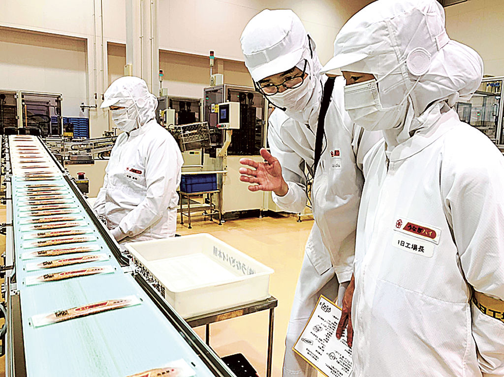 うなぎパイの製造工程を見学する木野さん（右）＝浜松市西区のうなぎパイファクトリー