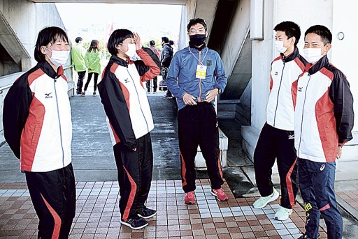 ４年ぶりに４人が集結し、長田監督と談笑する選手たち＝草薙陸上競技場