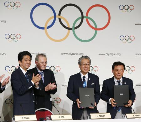 ２０１３年９月、２０年東京五輪の開催都市契約の調印式で安倍首相（左端）らと写真に納まる招致委の竹田恒和理事長（右から２人目）＝ブエノスアイレス（共同）